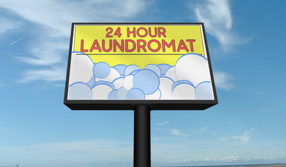 24 hour laundromat backlit banner sign with bubbles graphic, displayed outdoors on a billboard during daytime.